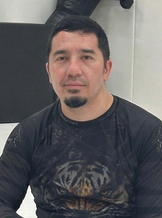 Coach Benjamin Frietze in a dark rash guard on the mat