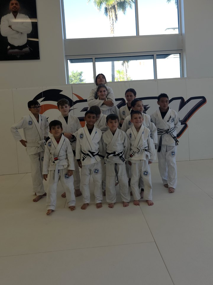 Flow Academy Riverside kids jiu-jitsu students in white gis on the mat