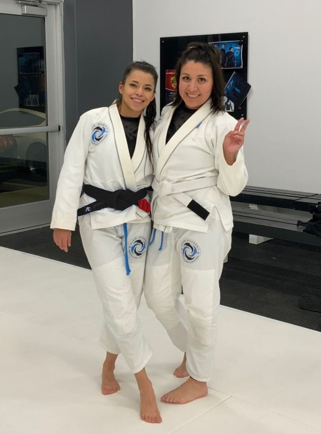 Professor Zaide with a student, both in white gis on the mat